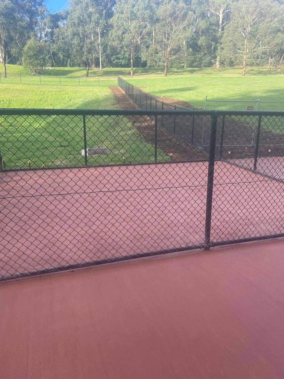 Coloured concrete sports court with chain mesh fence