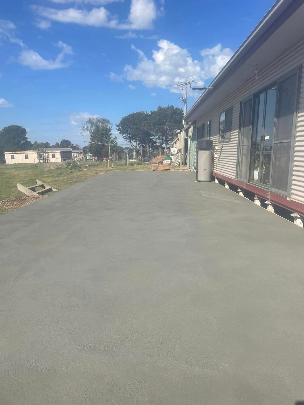 Freshly finished concrete slab beside a house