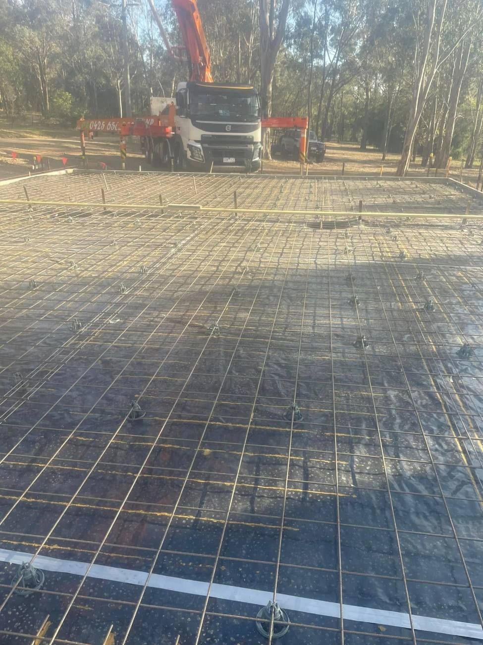 Reinforcing mesh laid for a large slab with a concrete pump truck on site